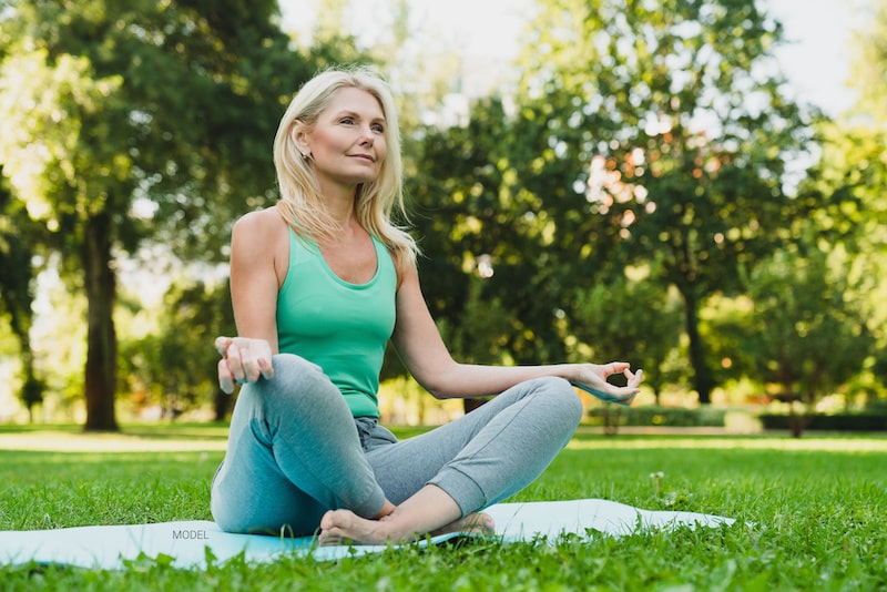 Beautiful and fit mature woman doing yoga in the park.